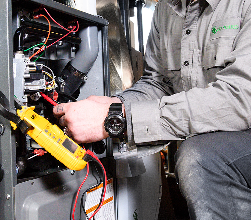 Standard technician testing wires of furnace