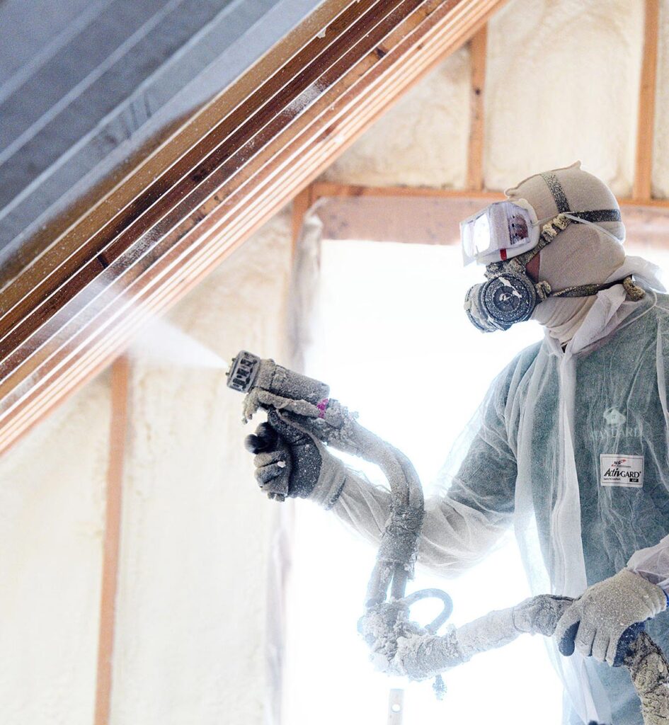 Standard technician spraying foam insulation