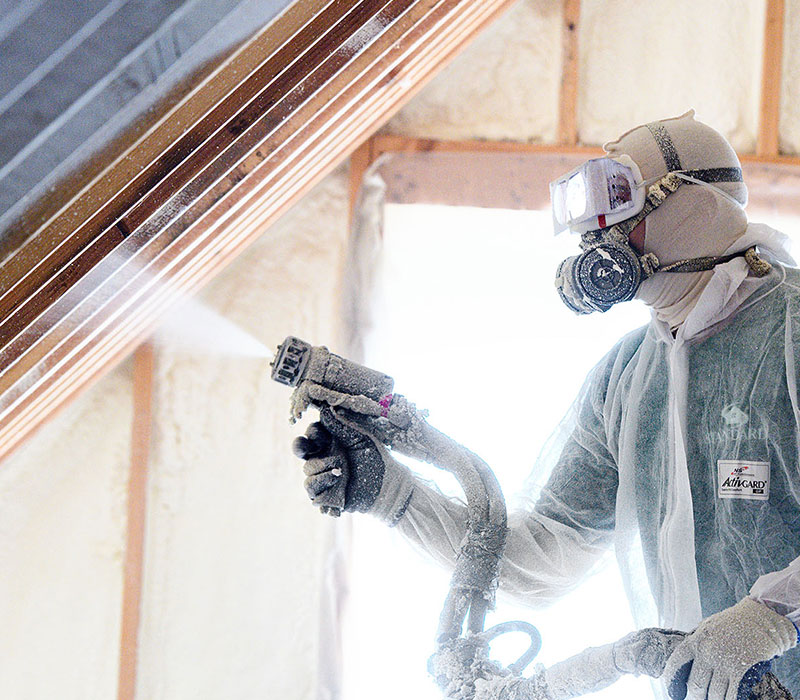 Standard technician spraying foam insulation