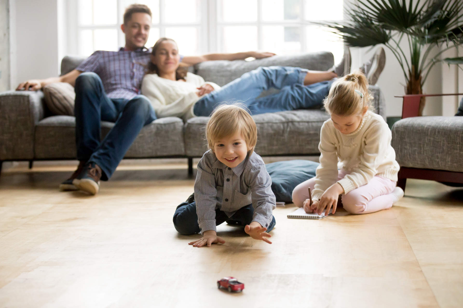 a family of four enjoying time together in a living room with a comfortable temperature after installing a heat pump