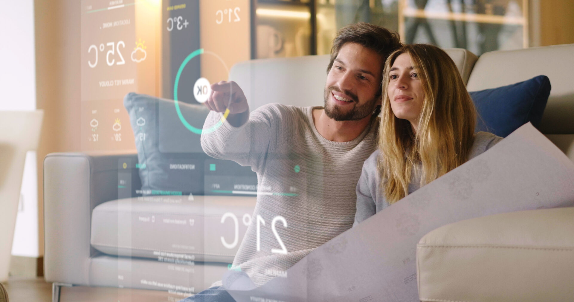 dark-haired bearded man and long-haired woman sit on a couch using smart home controls